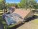 A sunny aerial view features a screened in pool, a fenced yard, and a home with a well-maintained roof at 40600 Louise Rd, Umatilla, FL 32784