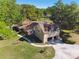An aerial shot showcases the home's architecture, well-manicured lawn, and convenient driveway with a two car garage at 40600 Louise Rd, Umatilla, FL 32784
