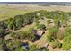 An aerial view displays the property's sprawling land, mature trees, screened in pool, and long, private driveway at 40600 Louise Rd, Umatilla, FL 32784