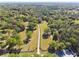 Aerial view of the tree-lined driveway leading to the home, surrounded by lush landscaping and mature trees at 40600 Louise Rd, Umatilla, FL 32784