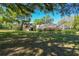 Expansive backyard featuring a screened pool, lush lawn and mature trees on a sunny day at 40600 Louise Rd, Umatilla, FL 32784