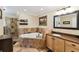 Stylish bathroom features a soaking tub, glass-enclosed shower, and wood vanity with sink at 40600 Louise Rd, Umatilla, FL 32784
