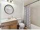 Clean bathroom with white walls, single sink vanity, toilet, and a shower with patterned curtain at 40600 Louise Rd, Umatilla, FL 32784