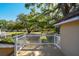 A cozy deck with a white railing overlooks a large yard with mature trees at 40600 Louise Rd, Umatilla, FL 32784