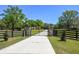 Gated driveway leading to a charming single-Gathering home with beautiful trees and landscaping at 40600 Louise Rd, Umatilla, FL 32784