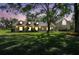 Charming home at twilight featuring dormer windows, covered porch, mature trees, and lush green lawn at 40600 Louise Rd, Umatilla, FL 32784