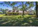 Charming home exterior with dormer windows, covered porch, mature trees, and lush green lawn at 40600 Louise Rd, Umatilla, FL 32784