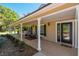 Charming front porch with seating and a decorative glass front door at 40600 Louise Rd, Umatilla, FL 32784
