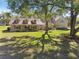 Charming single-story home featuring a covered porch, dormer windows, and mature landscaping at 40600 Louise Rd, Umatilla, FL 32784