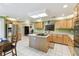 Spacious kitchen boasts stainless appliances, wood cabinets, island, and tile flooring at 40600 Louise Rd, Umatilla, FL 32784