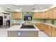 Bright kitchen features light wood cabinets, stainless appliances, island, and tiled floors at 40600 Louise Rd, Umatilla, FL 32784