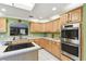 Kitchen features light wood cabinets, stainless appliances, an island, and tiled floors at 40600 Louise Rd, Umatilla, FL 32784