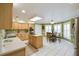Open kitchen with light wood cabinets, central island, tile floors, and adjacent dining area at 40600 Louise Rd, Umatilla, FL 32784