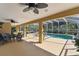Inviting screened lanai featuring ceiling fans, dining area, and view of a sparkling pool at 40600 Louise Rd, Umatilla, FL 32784