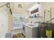 A well-organized laundry room includes a washer, dryer, storage shelves, and window at 40600 Louise Rd, Umatilla, FL 32784