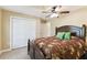 Main bedroom featuring a floral bedspread, closet, ceiling fan, and ensuite bathroom at 40600 Louise Rd, Umatilla, FL 32784