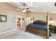 Spacious main bedroom featuring a four-poster bed, ceiling fan and ensuite bathroom access at 40600 Louise Rd, Umatilla, FL 32784