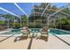 Relaxing poolside seating with a view of the spa and screened enclosure at 40600 Louise Rd, Umatilla, FL 32784