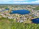 Expansive aerial view showcasing a community centered around a picturesque lake under clear skies at 4393 S Devon Ct, Kissimmee, FL 34746