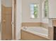 Bathroom featuring a separate glass door shower and jacuzzi tub with tile surround at 4393 S Devon Ct, Kissimmee, FL 34746