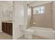 Bright bathroom featuring a bath tub with shower, toilet, and wooden vanity at 4393 S Devon Ct, Kissimmee, FL 34746