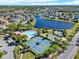 Expansive aerial perspective of neighborhood amenities, showcasing a large pool and tennis courts amidst lush landscaping at 4393 S Devon Ct, Kissimmee, FL 34746