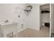 Functional laundry room with utility sink, storage shelving, and tile flooring at 4393 S Devon Ct, Kissimmee, FL 34746