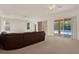 Bright living room with views of the pool, soft carpeting, and access to the outdoor patio at 4393 S Devon Ct, Kissimmee, FL 34746