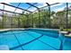 Private screened-in pool surrounded by lush landscaping provides a peaceful escape for relaxation and recreation at 4393 S Devon Ct, Kissimmee, FL 34746