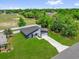 Aerial view of a well-maintained home with a long driveway and green lawn, highlighting its curb appeal at 4761 Sw 142Nd Place Rd, Ocala, FL 34473