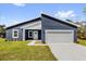 Contemporary blue home featuring a two-car garage, crisp white trim, and well-maintained lawn at 4761 Sw 142Nd Place Rd, Ocala, FL 34473