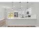 Modern kitchen with white quartz countertops, stainless steel appliances, and hard wood floors at 4761 Sw 142Nd Place Rd, Ocala, FL 34473