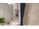 Bright bathroom features a modern vanity with a large mirror and a tub/shower combination with a blue curtain at 4839 Sunflower St, Lake Hamilton, FL 33851