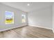 Bright bedroom with wood floors and two windows with a view of the outdoors at 531 Marion Oaks Blvd, Ocala, FL 34473