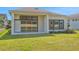 An inviting backyard with a well-maintained lawn and a covered patio area for outdoor enjoyment at 6239 Woodhaven Village Dr, Port Orange, FL 32128