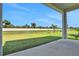 A covered patio overlooks a large backyard with a pond, fountain and a fence beyond at 6239 Woodhaven Village Dr, Port Orange, FL 32128
