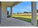 View from the covered patio to the large grassy backyard and distant fence at 6239 Woodhaven Village Dr, Port Orange, FL 32128