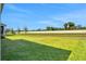 Grassy backyard with view of distant fence and blue sky at 6239 Woodhaven Village Dr, Port Orange, FL 32128
