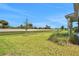 Grassy backyard with view of distant fence, blue sky and small trees at 6239 Woodhaven Village Dr, Port Orange, FL 32128