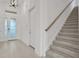 Bright entryway features a staircase, tiled flooring, and a glass-paneled front door at 6239 Woodhaven Village Dr, Port Orange, FL 32128