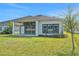 Exterior of home with backyard patio, windows and a grassy yard at 6239 Woodhaven Village Dr, Port Orange, FL 32128