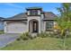 Well-maintained single-Gathering home with manicured lawn, two-car garage and inviting front entryway at 6239 Woodhaven Village Dr, Port Orange, FL 32128