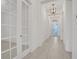 Hallway featuring tiled floor, glass paneled doors and modern light fixtures at 6239 Woodhaven Village Dr, Port Orange, FL 32128