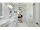 Stylish bathroom with dual sinks, marble floors, a glass shower, and access to the main bedroom at 705 Baffie Ave, Winter Park, FL 32789