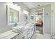 Bright bathroom with dual sinks, marble floors, a glass shower, and access to the main bedroom at 705 Baffie Ave, Winter Park, FL 32789