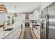 Spacious kitchen with a long island featuring stainless steel appliances, hardwood floors, and pendant lighting at 705 Baffie Ave, Winter Park, FL 32789