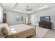 Comfortable main bedroom featuring a tray ceiling, hardwood floors, and a large window at 705 Baffie Ave, Winter Park, FL 32789