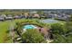 Aerial view of community pool, tennis courts, and homes in a lushly landscaped neighborhood at 910 Suffolk Pl, Davenport, FL 33896