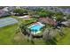 Aerial view of a community pool area with tennis courts, a volleyball court and green space at 910 Suffolk Pl, Davenport, FL 33896