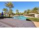Beautiful community pool area with lush landscaping, palm trees, lounge chairs, and covered seating areas at 9743 Amber Chestnut Way, Winter Garden, FL 34787